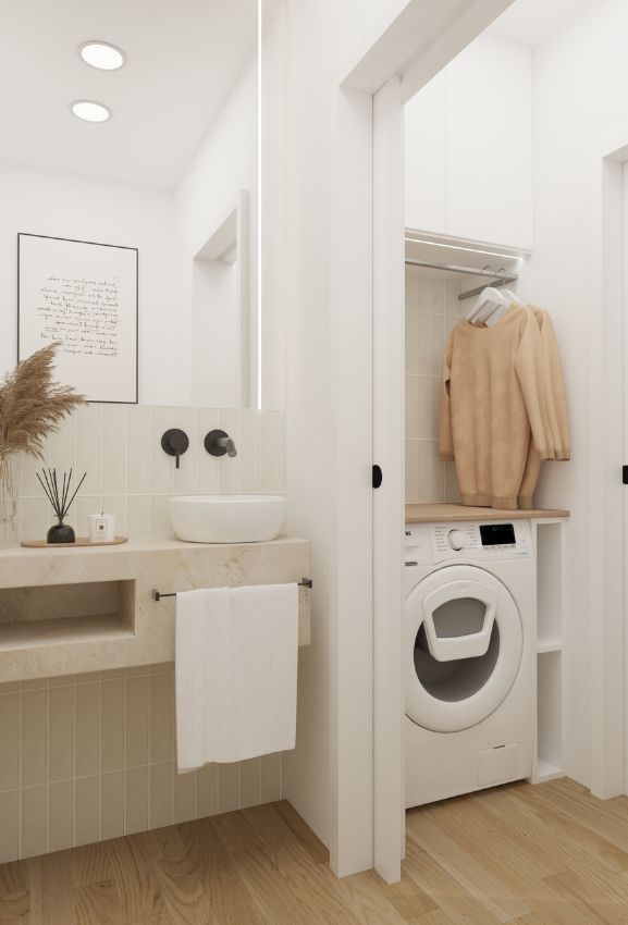 alt="Design de lavandaria minimalista integrada com máquina de lavar e bancada em branco."