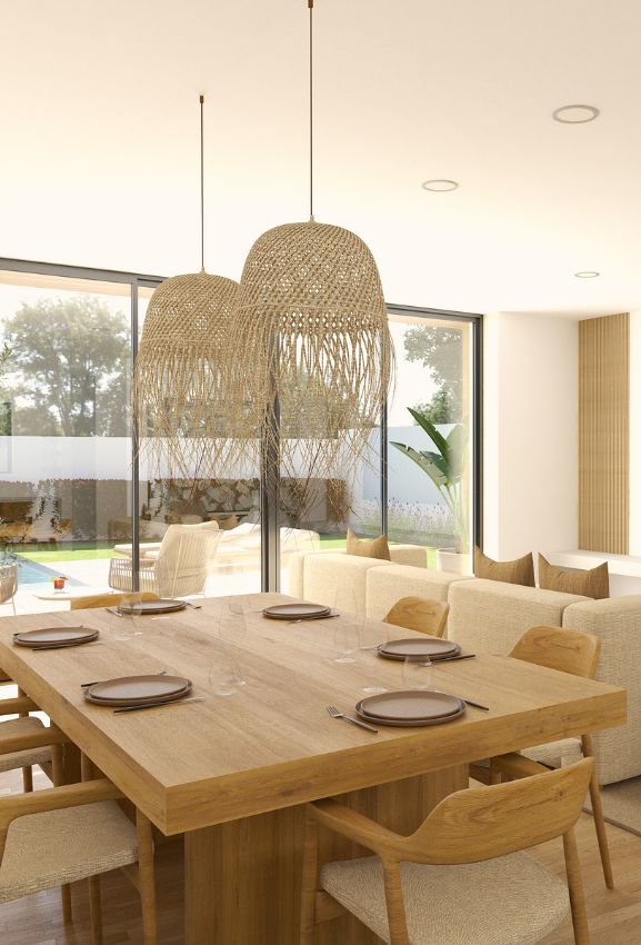 alt="Design de interiores para alojamento com mesa de madeira maciça e candeeiros de vime."